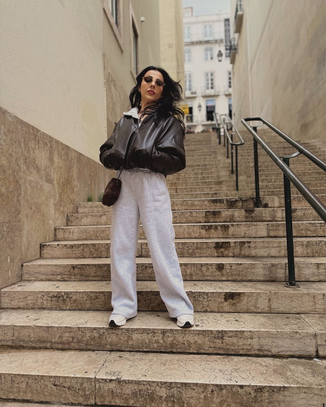 Frau in Lederjacke auf einer Stiege in Lissabon